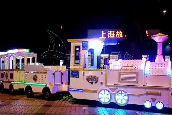 White Trackless Train Rides Sides at Night